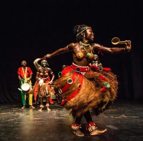 Bailarina em cena com saia de palha e músicos ao fundo, em espetáculo de edição anterior do Circuito